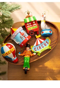 Detailed view of circus themed Christmas ornaments set displayed on a rustic wooden tray