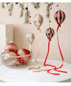 Détails macro des ornements de Noël en forme de montgolfière champagne et rouge sur sapin