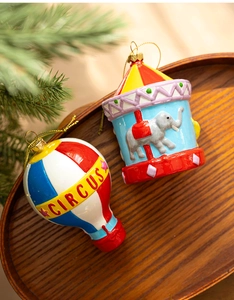 Detail of circus hot air balloon and carousel ornaments on a rustic wooden tray