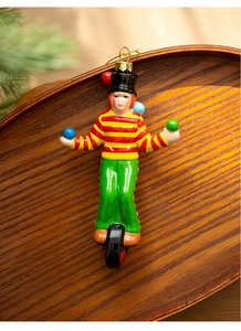 Macro shot of circus juggler Christmas ornament with a unicycle in a wooden tray