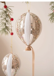 Détail d'un ornement ballon champagne 15cm avec paillettes sur branche de sapin de Noël