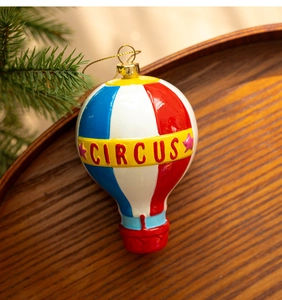 Detail of a red and blue circus hot air balloon Christmas ornament on a wooden tray