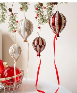 Détail de quatre suspensions de Noël en forme de montgolfière couleur champagne et rouge festif