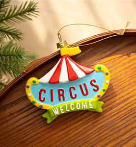 Detail of circus theme Christmas ornament with Welcome text on a rustic wood background