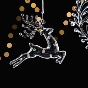 Elegant transparent acrylic Christmas reindeer ornament with white floral patterns on black background
