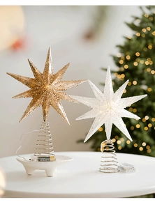 Close-up of champagne and silver glitter star tree toppers with LED battery boxes