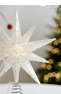 Close-up of white glitter Christmas tree topper star with warm yellow LED lights