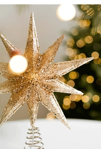 Close-up of champagne gold glitter star tree topper with metal spiral base stand