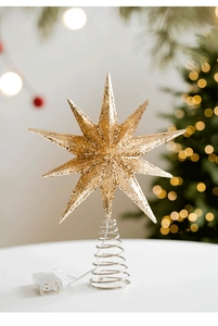 Close-up of champagne gold glitter star tree topper with a glowing spiral base