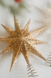 Close-up of champagne gold glitter star tree topper with a spiral spring metal base