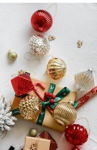Detail of assorted Christmas glass ornaments in red, gold, and silver on a festive background