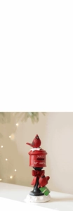 Close-up of red Christmas mailbox figurine with Santa mail text and cardinal birds