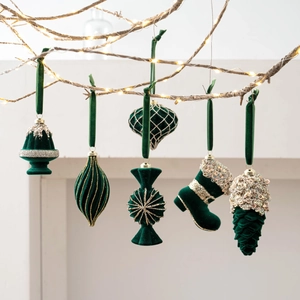Dark green flocked Christmas ornaments set with gold glitter accents on festive branches