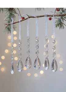 Close-up of clear acrylic teardrop ornaments hanging on Christmas tree branches