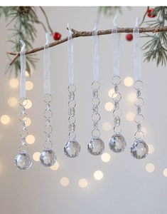 Macro detail of transparent acrylic snowflake charms with crystal beads on a Christmas tree