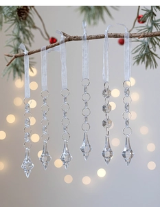 Set of 6 clear acrylic icicle ornaments with pearl teardrops hanging on Christmas tree