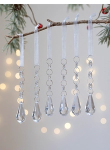 Macro view of crystal teardrop ornaments with white ribbons for Christmas tree decor