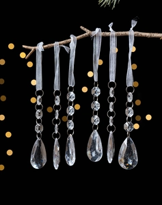 Macro view of crystal teardrop pendants with octagonal beads on snowy ribbons