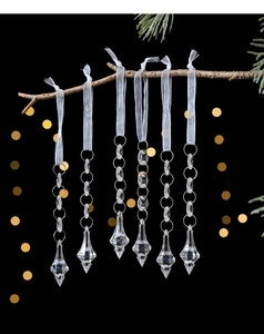 Close-up of clear acrylic snowflake ornaments with faceted crystal drops on tree branches