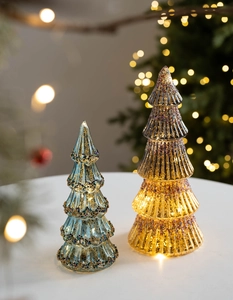 Gros plan de sapins de Noël en verre lumineux avec paillettes et lumières LED