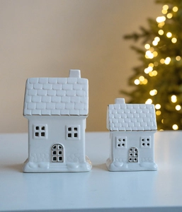 Close-up of white ceramic lit houses with gold trim for Nordic Christmas decor