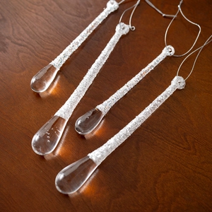Set of 4 clear glitter icicle Christmas tree ornaments on a vintage wood surface
