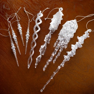 Set of 7 clear acrylic icicle Christmas ornaments with silver glitter on wood background