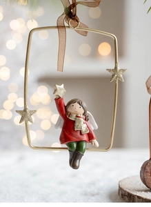 Detailed view of girl resin figurine in star frame hanging on a festive Christmas tree