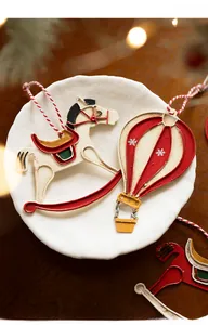 Close-up of vintage Christmas ornaments featuring a painted rocking horse and hot air balloon