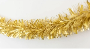 Close-up of golden Christmas tinsel garland with shiny PET metallic foil texture