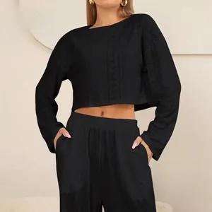 Dames set met zwarte crop top met lange mouwen en wijde broek in opengewerkt breisel