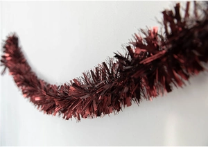 Close-up of fluffy metallic dark red tinsel garland for Christmas and wedding decor