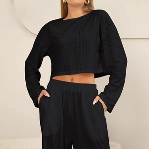 Zwarte tweedelige damesset met crop top met lange mouwen en opengewerkte laser-broek