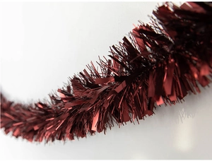 Macro shot of fluffy dark red tinsel garland with metallic shine for holiday decor