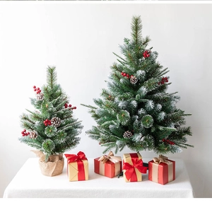 Close-up of snow-flocked Christmas tree branches with red berries and natural pine cones