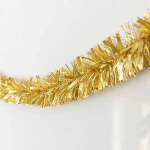 Shiny gold Christmas tinsel garland for festive holiday and party decoration