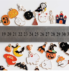 Flat lay of diverse Halloween enamel charms showing measurements with a metal ruler