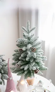 Close-up of 60cm snow-flocked Christmas tree with pine cones and a solid wooden base