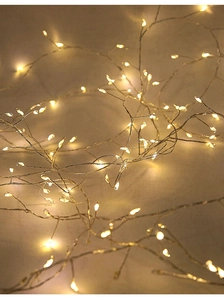 Vue macro de guirlandes lumineuses à LED blanc chaud en cuivre avec perles denses