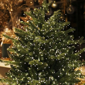 Guirlande lumineuse LED blanc chaud enroulée autour d'un sapin de Noël bien vert