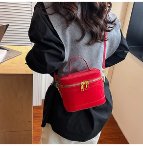 Sac bandoulière rouge en daim avec gaufrage léopard porté par un mannequin