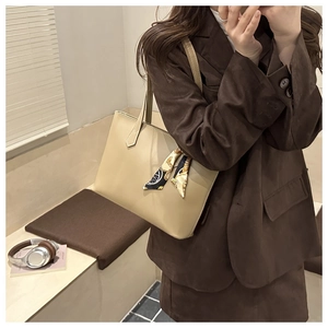 Close-up of beige lychee pattern tote bag with decorative silk scarf and wide handle
