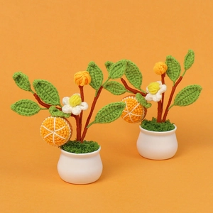 Detail of two handmade crochet orange tree mini bonsai in white matte ceramic pots