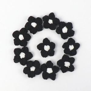 Detailed macro view of 11 handcrafted black and white crochet puff flowers for DIY crafts