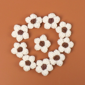 Macro view of ten handmade crochet puff flowers in cream and brown yarn material