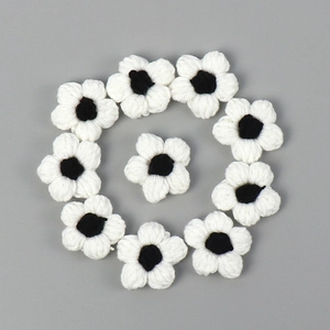 Detail of 10-piece black and white handmade crochet puff flowers for DIY craft accessories