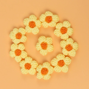 Close-up of 10 handmade crochet macaron puff flowers for DIY hair clips and clothing