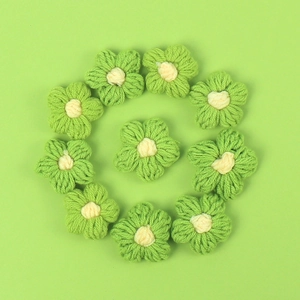 Detail of 11 handmade crochet green flowers with yellow centers for DIY accessories