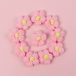 Macro shot of 11 handmade pink crochet macaron flowers for DIY hair accessories