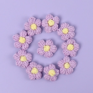 Detail of 11 purple crochet puff flowers with yellow centers for DIY hair accessories